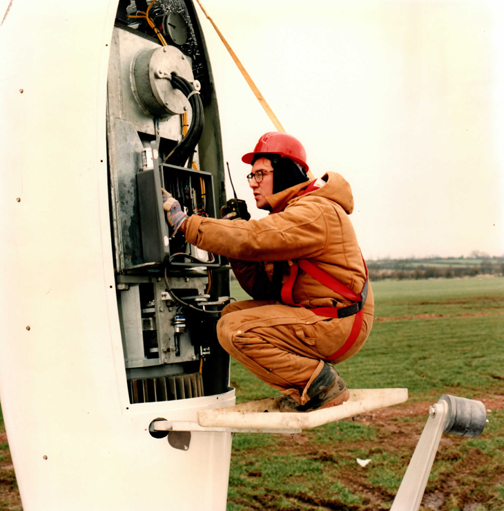 Engineer wiring the nacelle switchgear at standing height — tilt-down turns tower-top work into ground-level work.