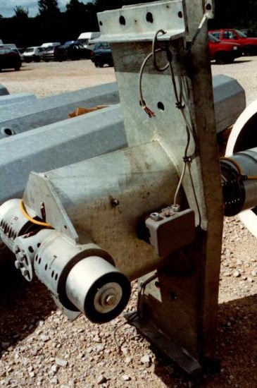 Close-up of the teeter bearing assembly at the rotor hub that supports the two blades, with wiring and a junction box visible